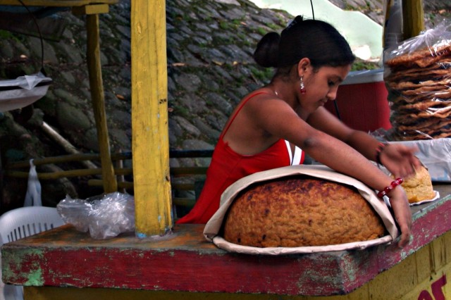Person selling roadside arepas, tortas and johnnycakes