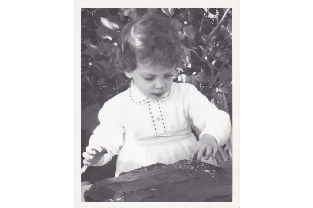 Karen Hirsh as young girl decorating a cake. 