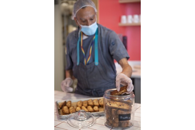 Man placing biscotti in a jar