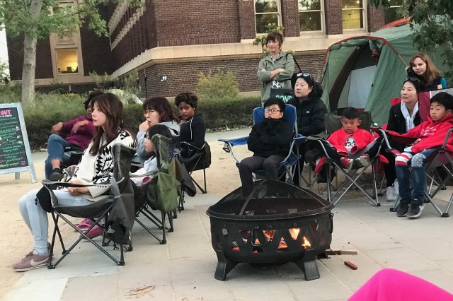 Participants from Black Girls Trekkin&#039;, Korean American Family Services gather around a campfire