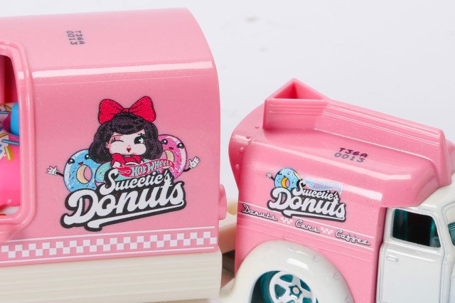 A close of a pink hot wheels rig shows a logo of a lady with brown hair and a red bow