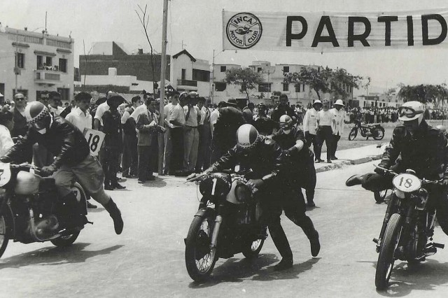 Three riders jump onto their motorcycles at the start of a race.