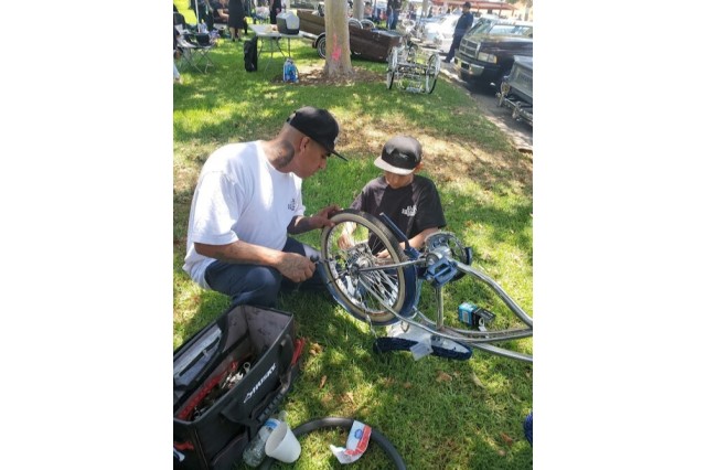 Sandy&#039;s husband and son working on lowrider bike together.