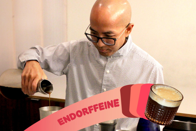 Bald man in glasses using a pipette to measure ingredients into a custom coffee drink.