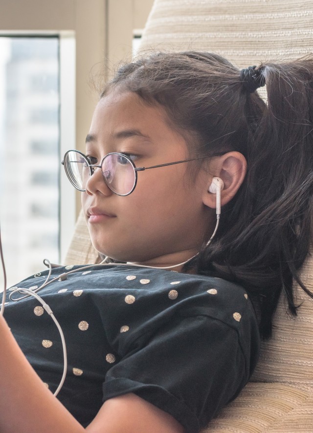 Child using tablet with headphones on