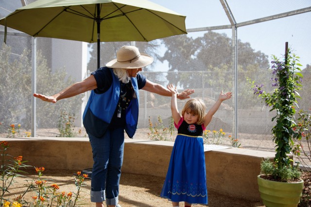 female volunteer with child in butterfly pavilion