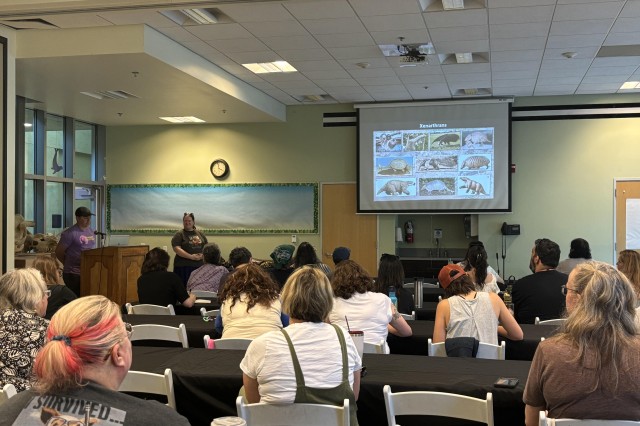 Five rows of educators sitting facing a projector screen. The screen is showing a slide of xenarthrans.
