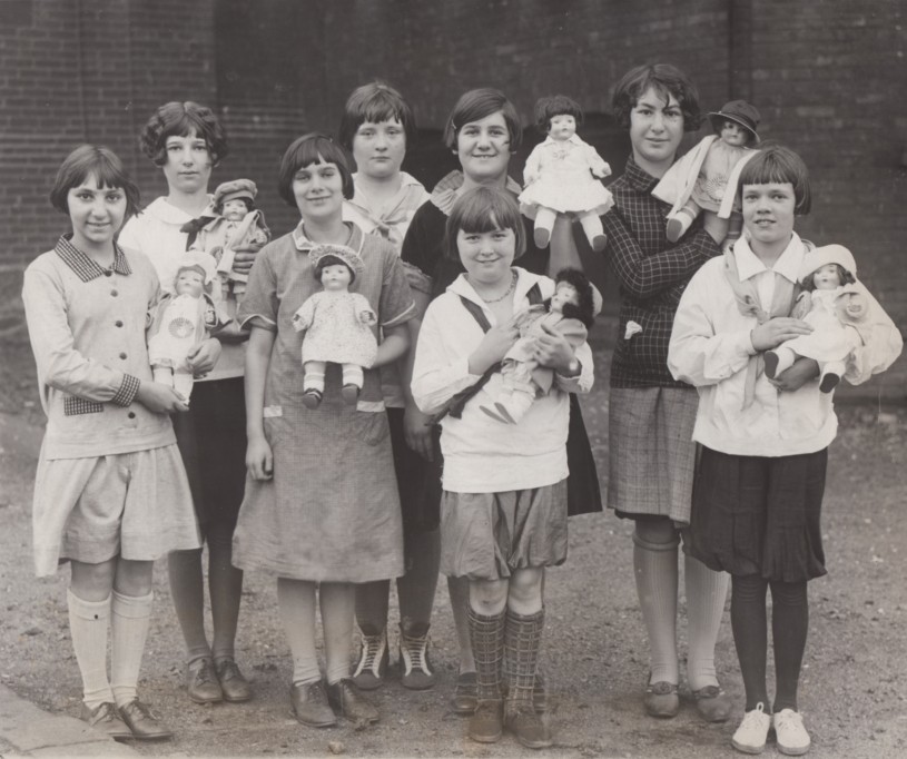 Group of girls holding "blue-eyed' dolls