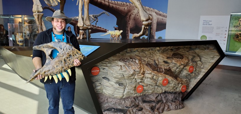 Man in hat holding fossil 