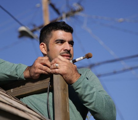 Miguel setting up a bat detector on a children's play structure in a South L.A. backyard.
