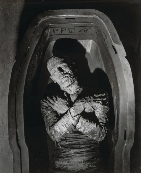 Still image from horror film The Mummy. The Mummy lies in a sarcophagus with arms crossed. 